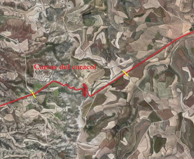 Una vez dejado atrás el pueblo de La Muela, la antigua N-II se adentra por los terrenos dónde se encuentran los famosos molinos de viento. A mitad de camino de la imagen, veréis que hay delimitado con unas líneas amarillas perpendiculares el itinerario de la carretera. Ese tramo es conocido como "Las curvas del caracol". Como su nombre bien indica, se trata de un recorrido con una serie de curvas entrelazadas izquierda-derecha para salvar la altitud que ahora se descenderá hacia los 520 metros.